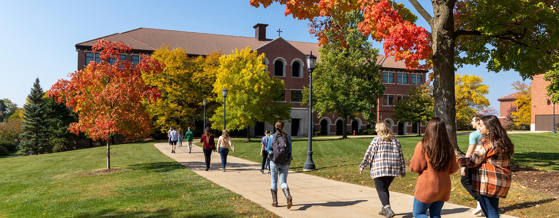 Students walking into Generac Hall in autumn